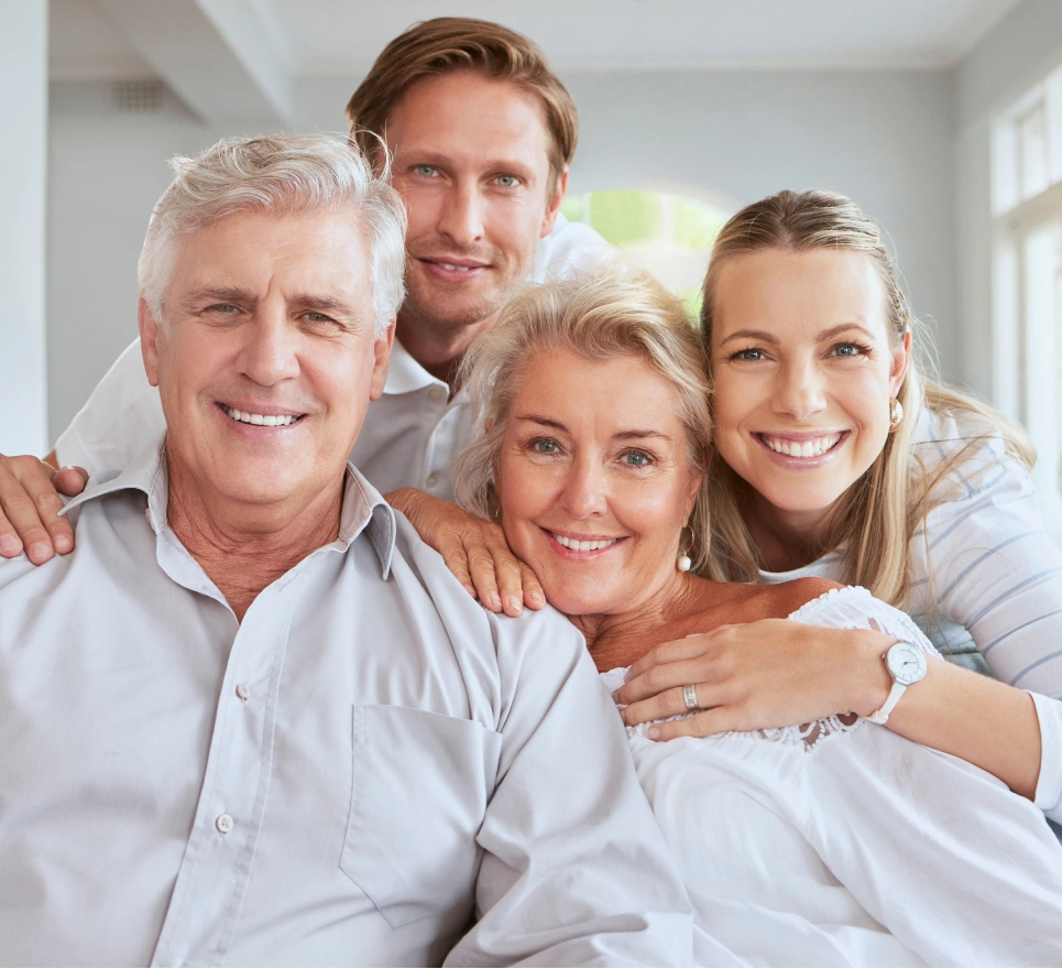 Happy multi-generational family smiling together in bright, modern home interior.