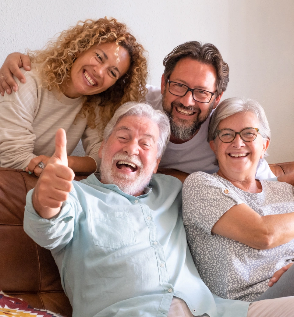 Happy multigenerational family smiling together indoors, showing dental health and wellness.
